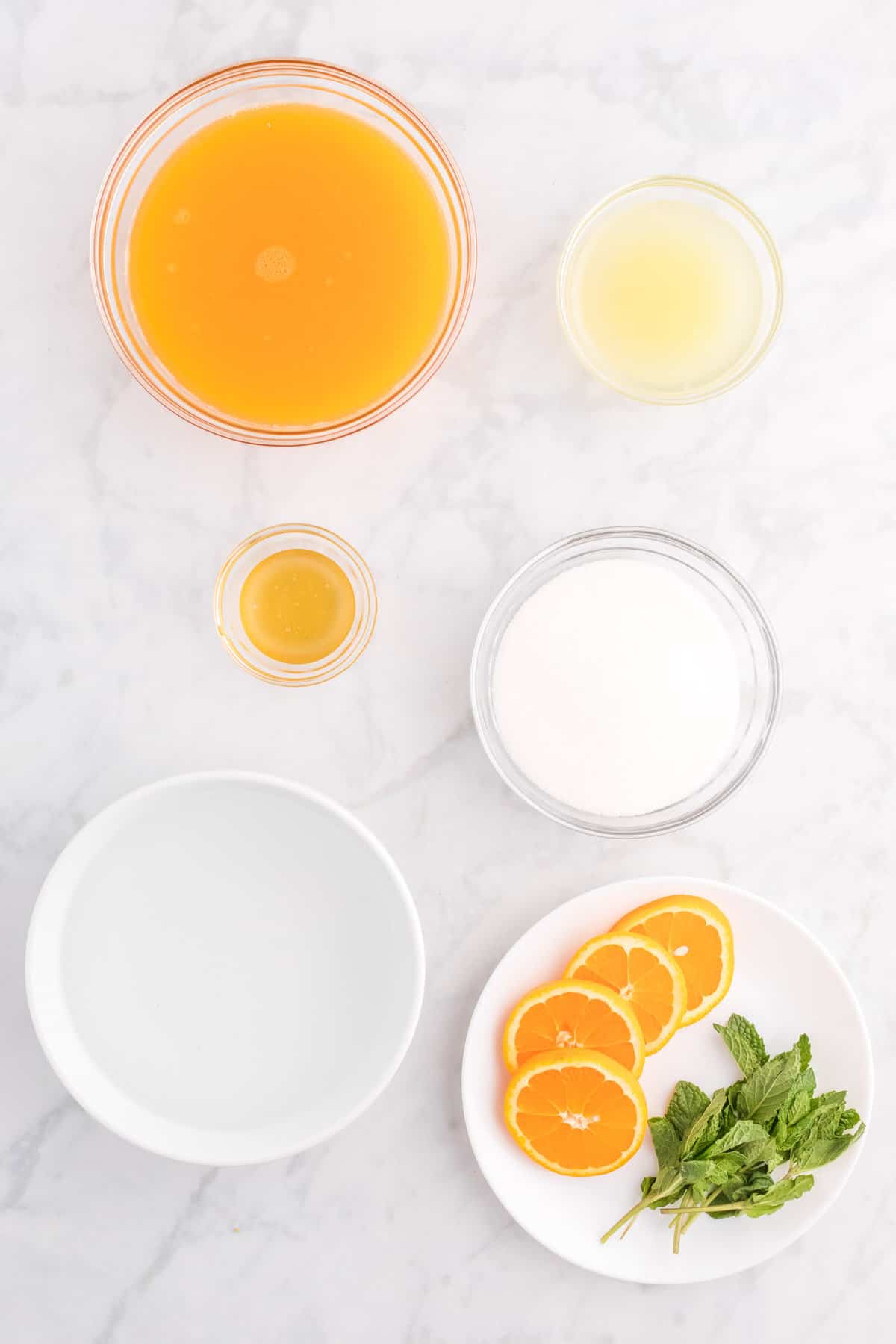 Overhead view of ingredients including orange juice and lemon juice.