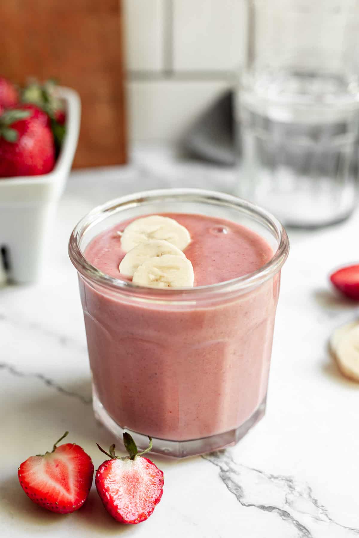 Strawberry banana peanut butter smoothie topped with sliced bananas.