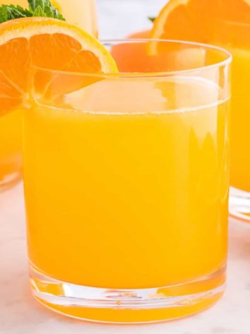 Orangeade in a short glass with an orange slice.