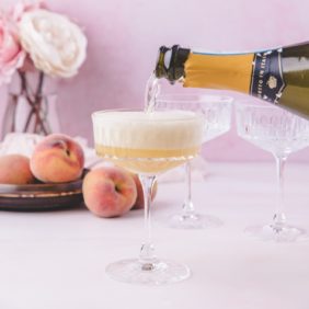 Prosecco being poured into a peach Bellini.