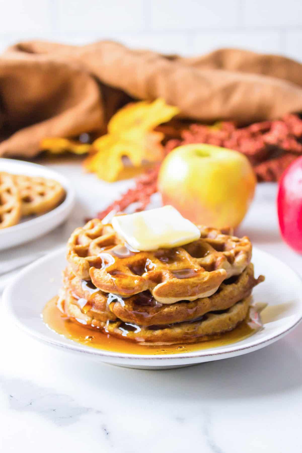 Apple cider waffles topped with butter and syrup.