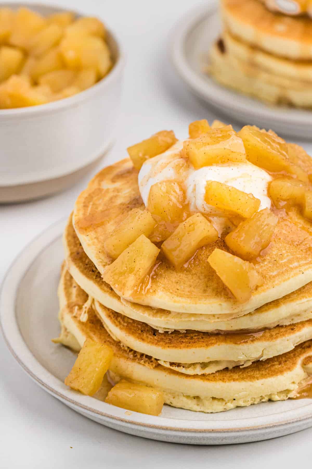 Pineapple sauce on top of stack of pancakes.