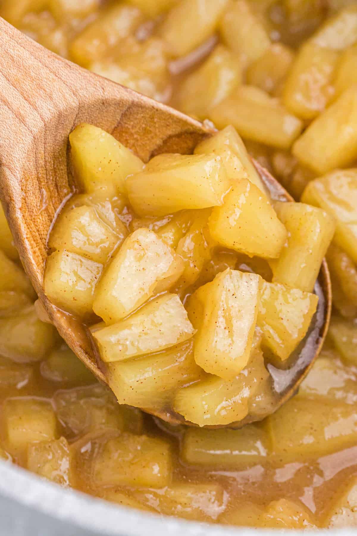 Caramelized pineapple on wooden spoon.