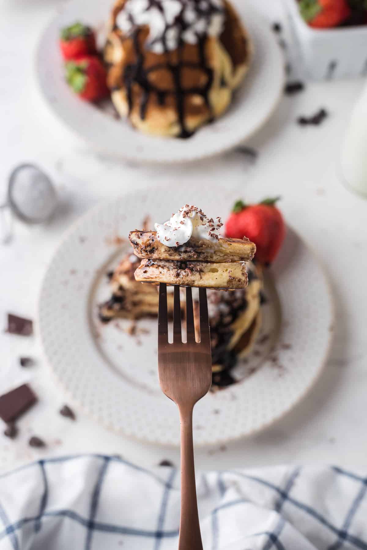 Cut pancake on a fork, showing chocolate chips.