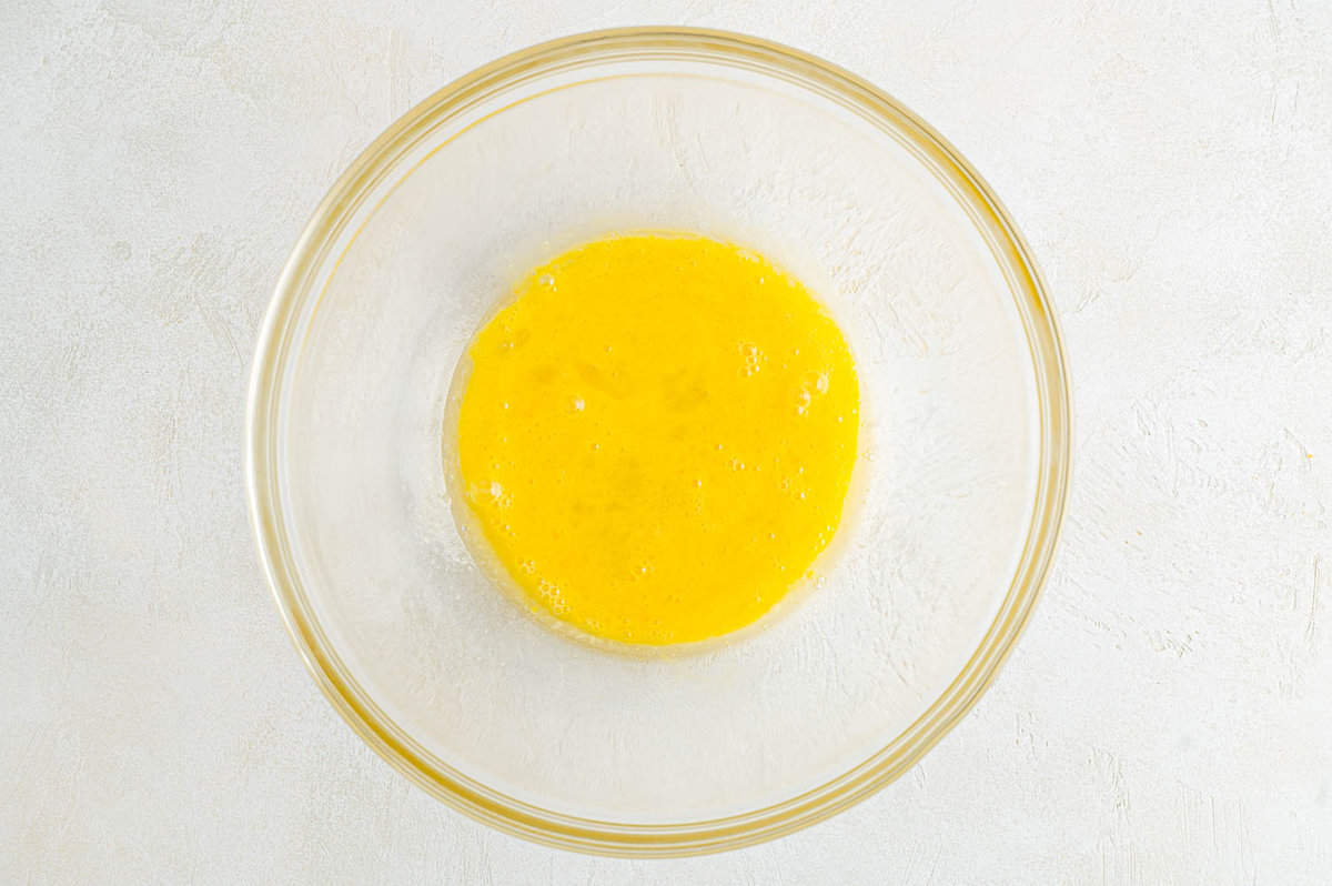 Eggs and butter whisked together in mixing bowl.