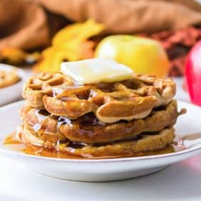 Apple cider waffles with butter and syrup.
