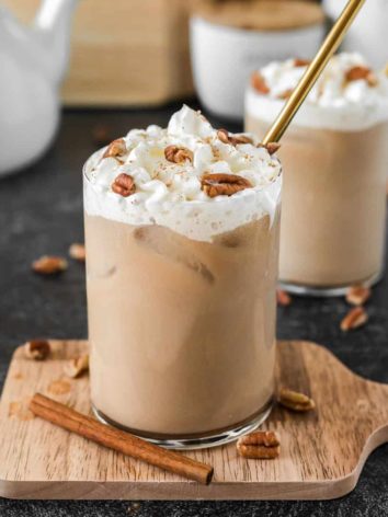 Maple pecan latte with whipped cream, pecans, and a straw.