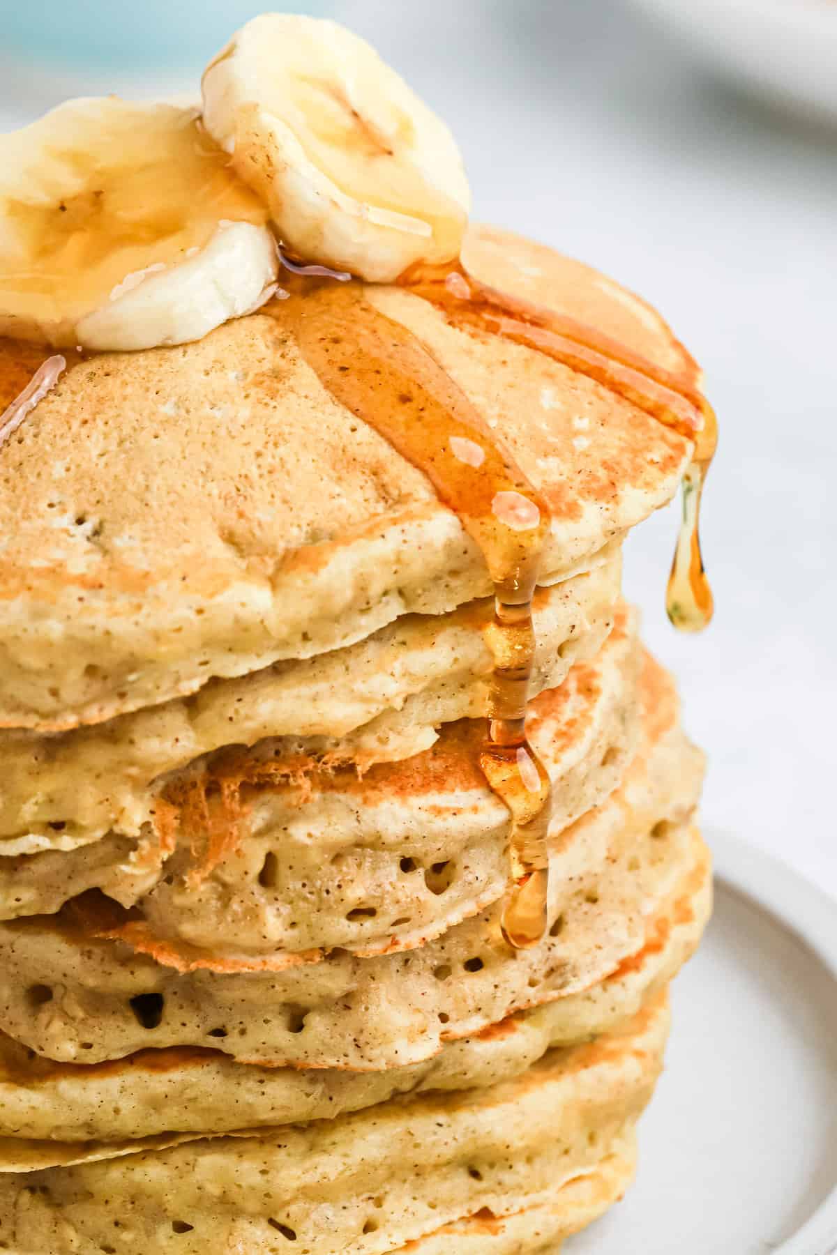 Stack of pancakes with syrup dripping off it.