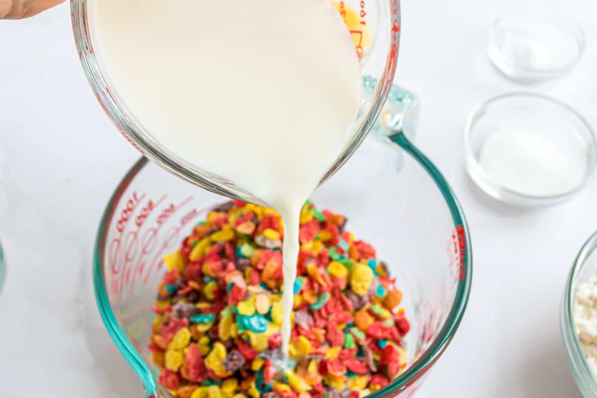 Milk being poured over cereal.