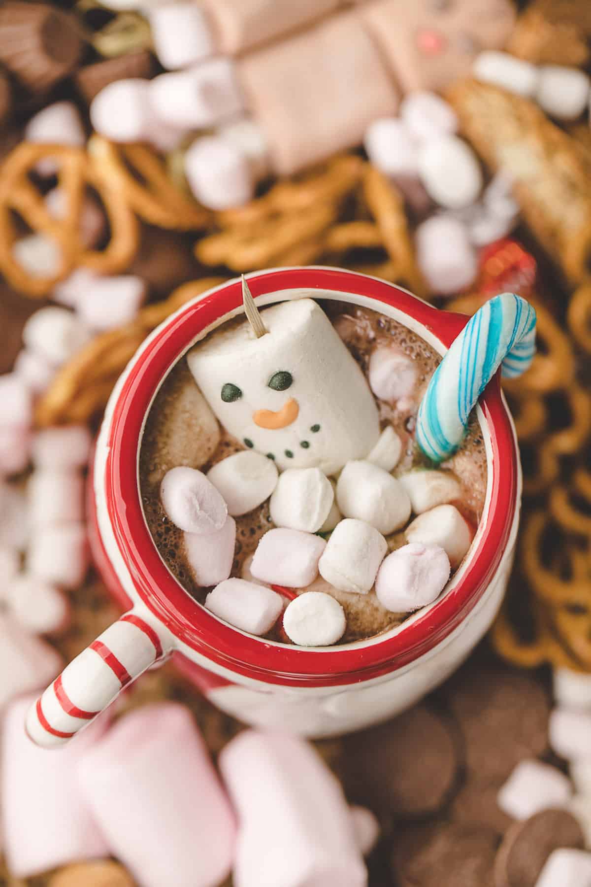 Hot cocoa in a mug surrounded by treats.