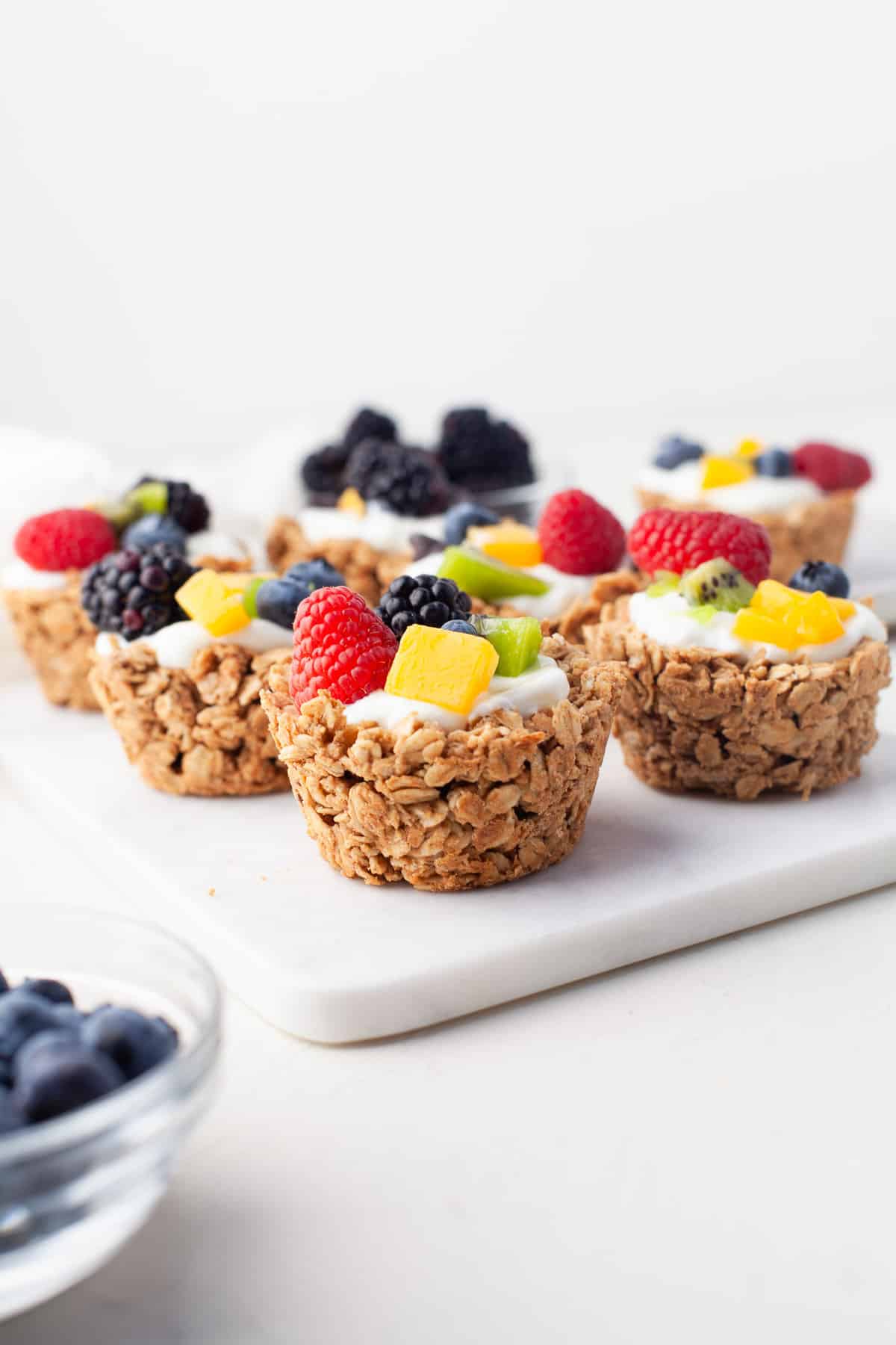 Oatmeal cups with fruit, on a white surface.
