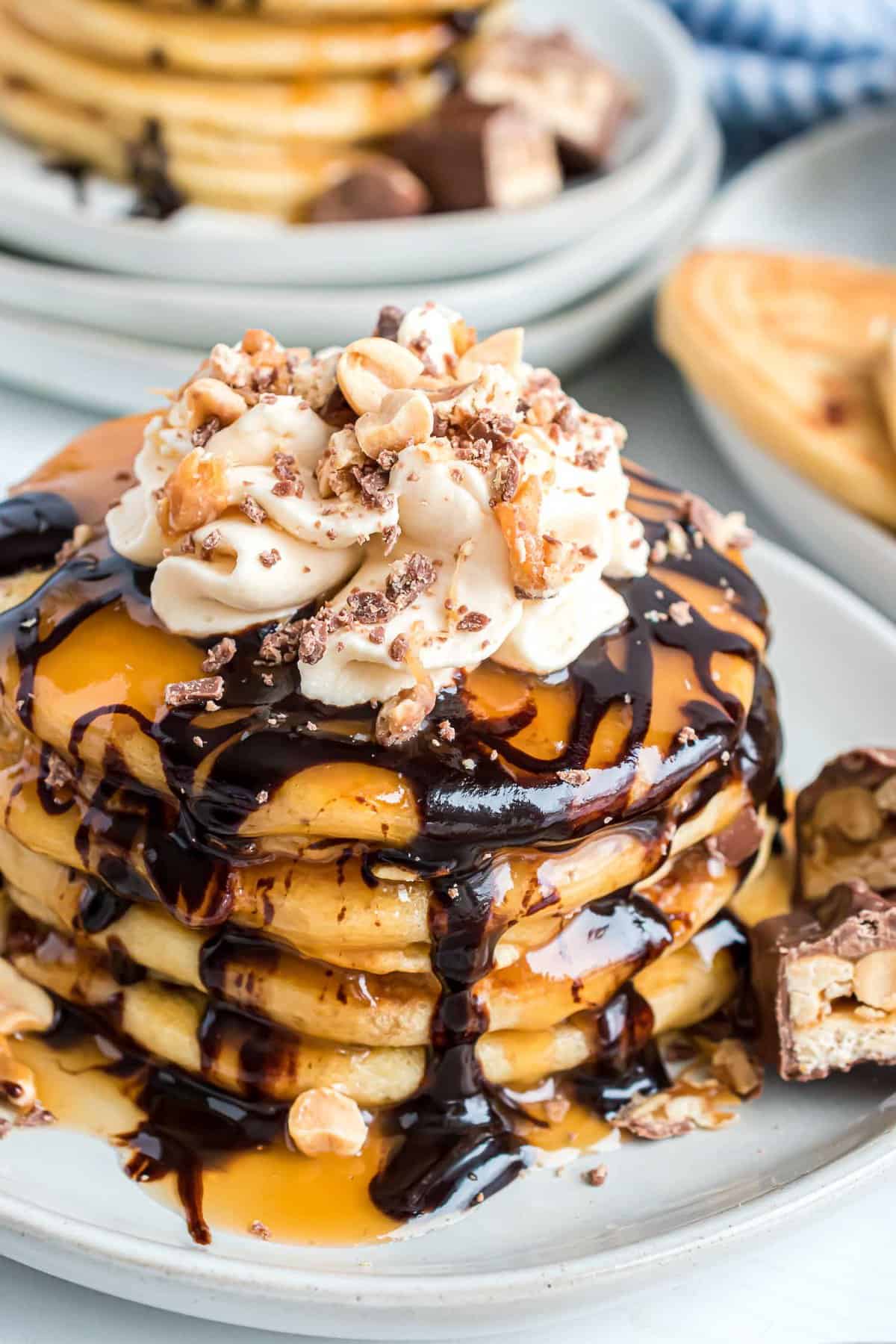 Snickers pancakes with caramel and chocolate sauce.