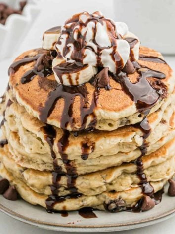 Stack of banana chocolate chip pancakes with chocolate syrup.