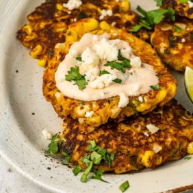 Street corn fritters with sauce and cilantro garnish.